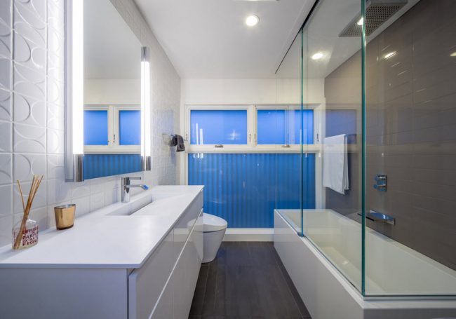 Просторная ванная комната с большой стеклянной шторкой и яркими синими цветовыми акцентами