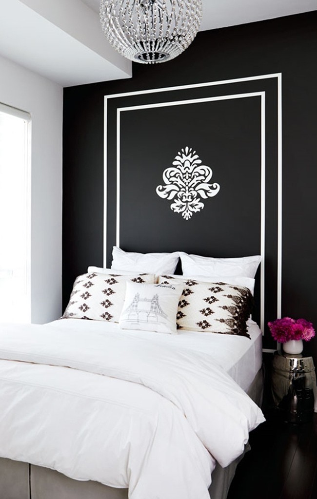 Белый трафаретный рисунок в качестве изголовья кровати будет смотреться очень выразительно на черной стене