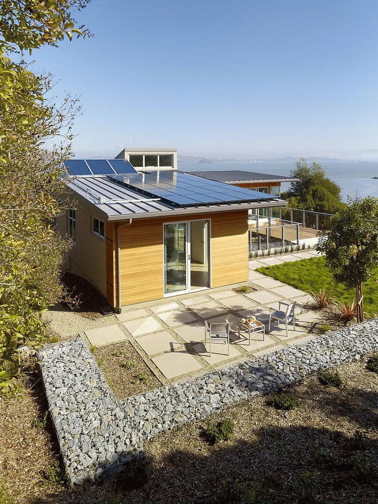 На плоской крыше небольшого дому установлены солнечные батареи