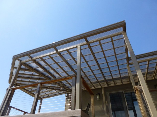 Навес из поликарбоната, пристроенный к дому, защитит вас от палящего солнца и атмосферных осадков