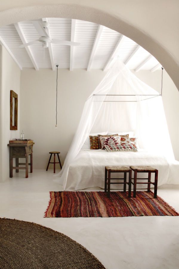 Кровать под прозрачны легких балдахином в белой спальне