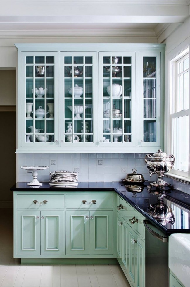 Мятные шкафы в традиционном исполнении наполнены декорирующей интерьер посудой