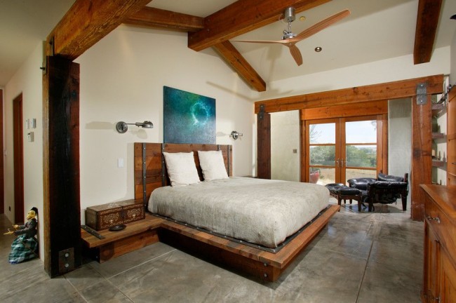 "Сырой", брутальный стиль оформления современного дома с деревянными фальшбалками, деревянными окнами и с деревом же для подиума под кровать в спальне