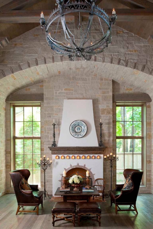 Красивый интерьер гостиной с двумя напольными канделябрами у камина