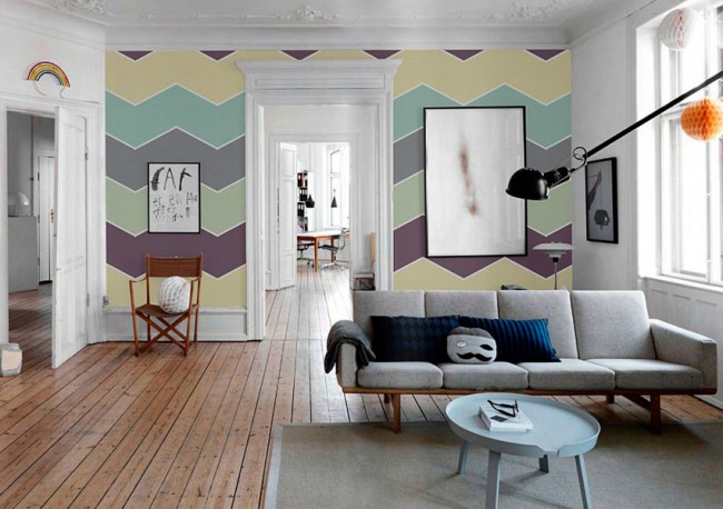 В комнате с высокими потолками разноцветные обои зигзагообразного рисунка
