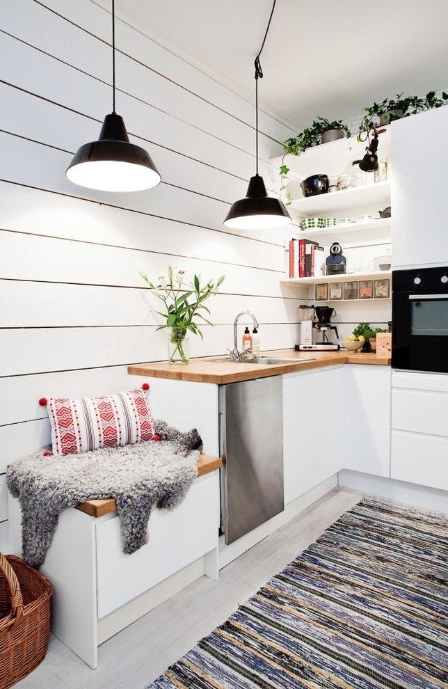 Уютная белая кухня в скандинавском стиле с полосатой дорожкой на полу
