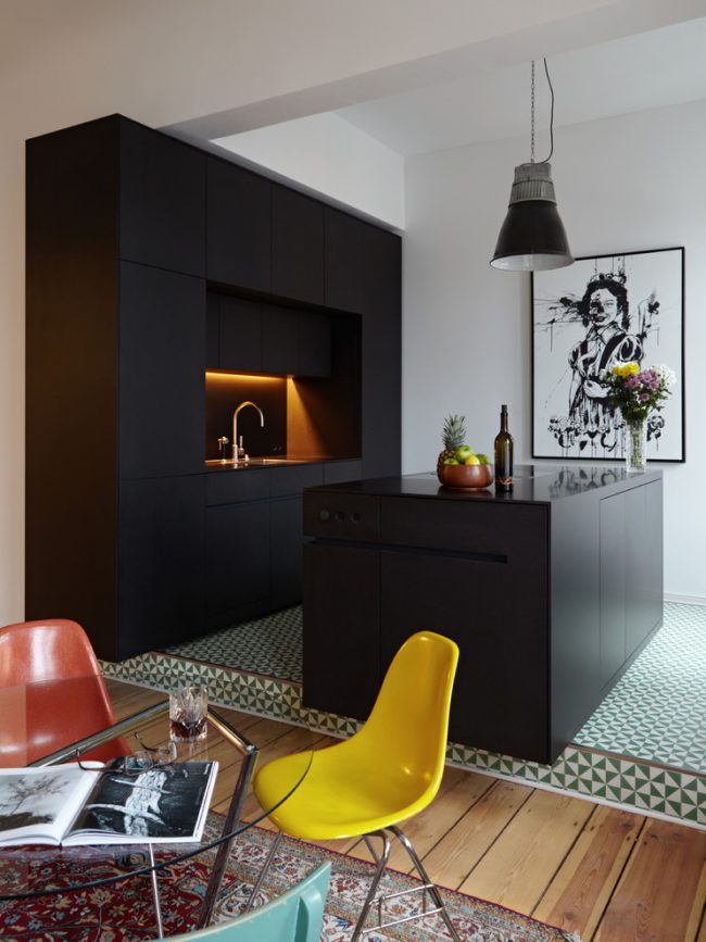 Матовый черный кухонный гарнитур и подсветка подвесных шкафов и рабочей поверхности желтоватым светом