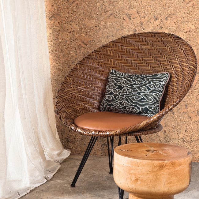 Натуральную пробковою стену дополнит плетеный стул и табурет из дерева