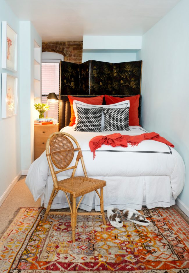 Узкая спальня с белыми стенами и уютным текстилем в теплых тонах