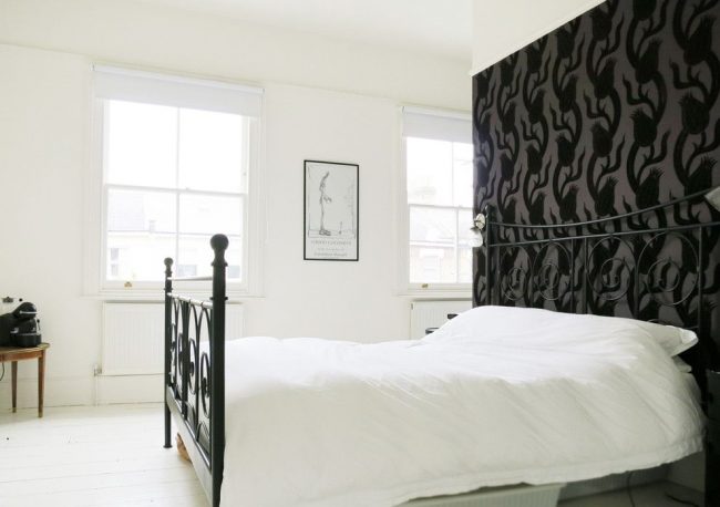 Контрастный черно-белый интерьер спальни с белым радиатором под окном