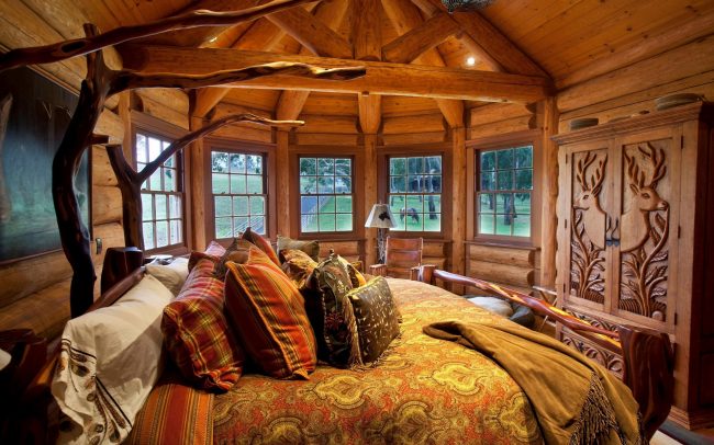 Спальня в деревенском стиле: много окон, резная мебель и декор кровати с помощью дерева