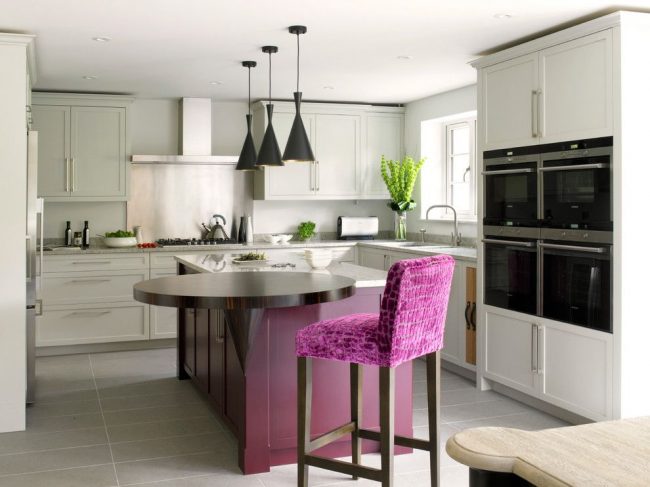 Модная лондонская кухня в серо-фиолетовой цветовой гамме с лаконичной мебелью. Круглое обеденное место оригинальной модификации – с подпоркой, являющееся продолжением кухонного острова