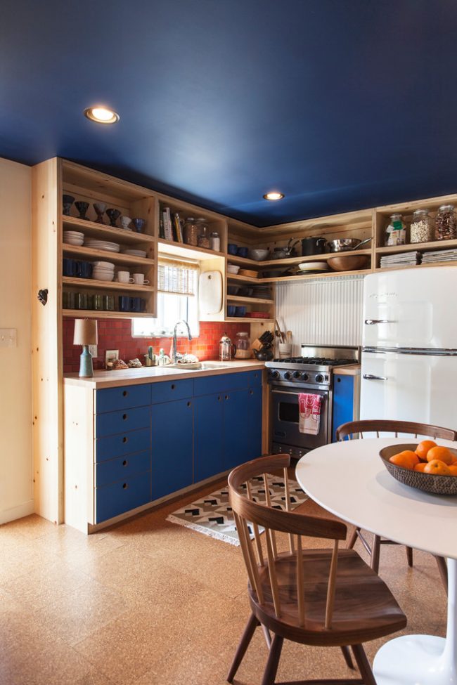 Удачное сочетание синего цвета и деревянной мебели в интерьере кухни