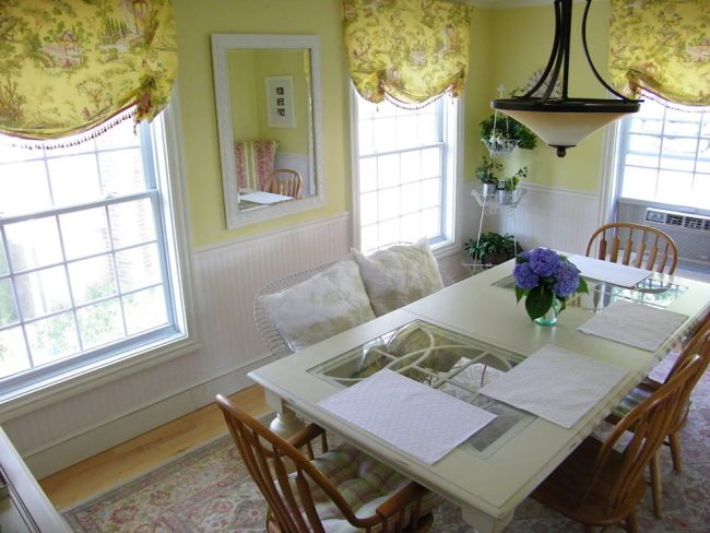 Нежная и уютная столовая благодаря светлым оливковым оттенкам стен и штор