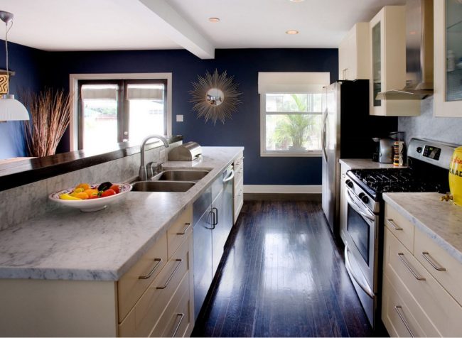 Темные синие обои на кухне можно "разбавить" светлым кухонным гарнитуром и белыми потолками