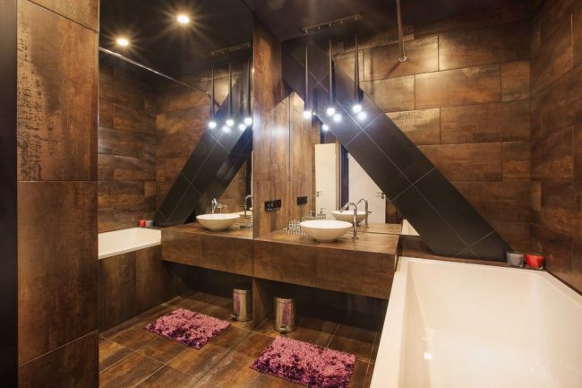 Небольшая ванная комната в темном цвете может быть визуально увеличена за счет большого зеркала