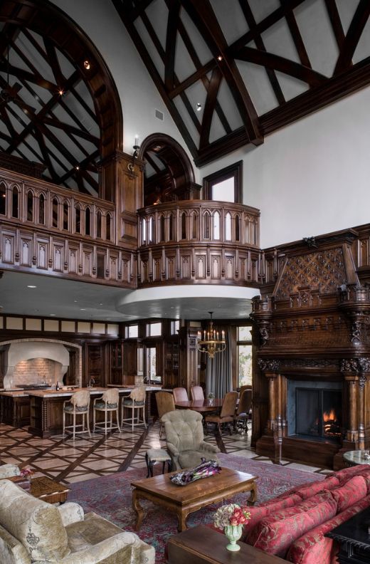 Готическая гостиная украшена резными элементами из темного дерева: перила, камин, стены и даже мебель