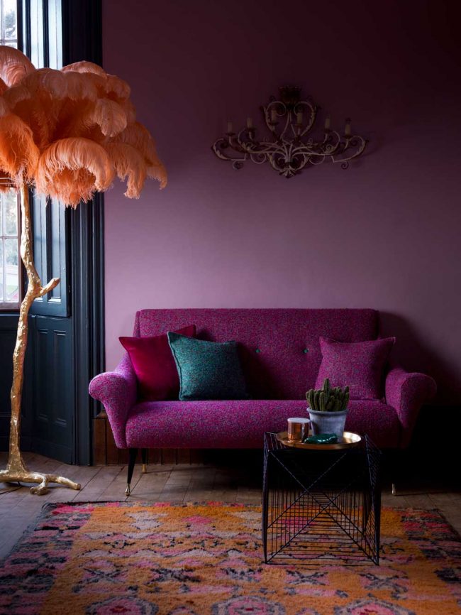 Уютная гостиная с сиреневыми обоями в пастельных тонах и ярким акцентом на комфортном диванчике
