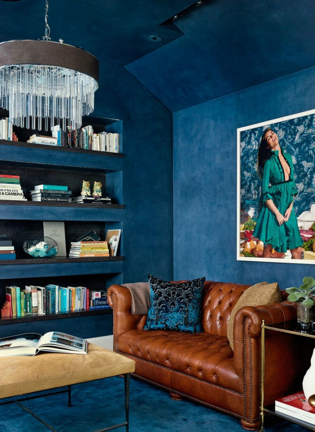Красивый синий интерьер в стиле фьюжн с небольшим диваном Честерфильд коричневого цвета