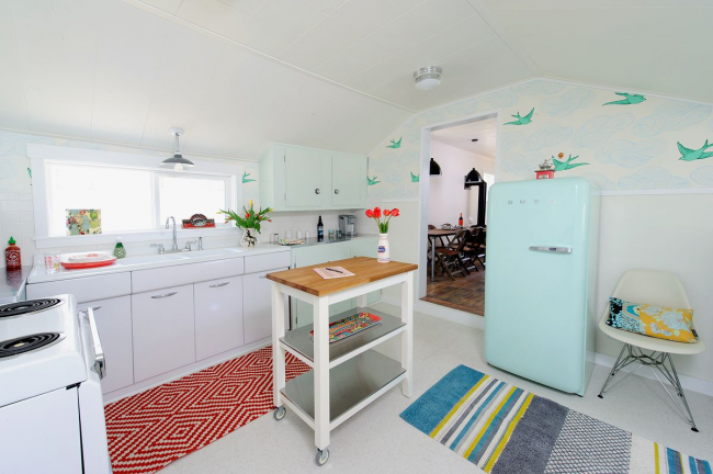 Нежный холодильник светлого голубого оттенка на небольшой кухне, зонированой с помощью цветовых акцентов