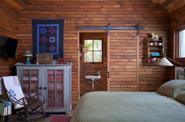 Очень атмосферная спальня загородного домика с деревянной дверью-купе