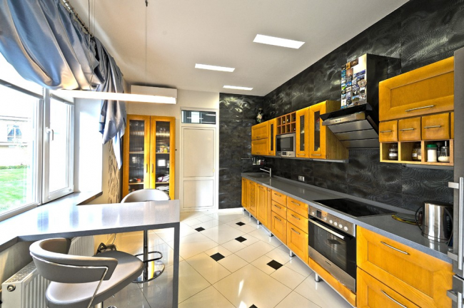 Необычное сочетание черных обоев с "грязно"-желтым кухонным гарнитуром и белой параллельной стеной