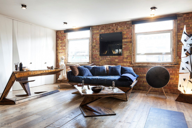 Деревянная мебель и кирпичная стена в оформлении гостиной стиля лофт