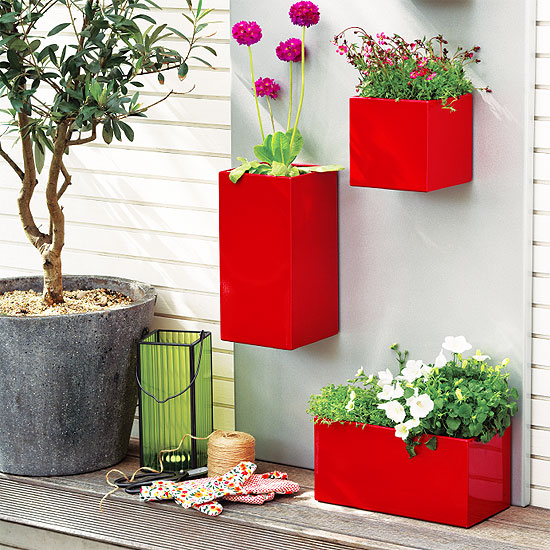 Яркая композиция с трех красных вазонов с цветами украсит уголок для отдыха